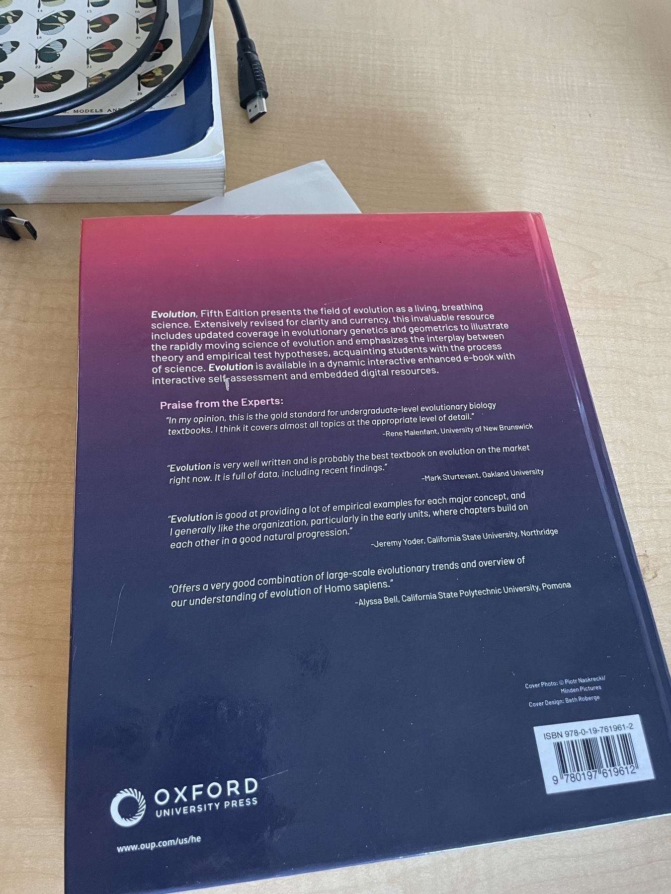 The same textbook, flipped over to show the back cover, which has a list of blurbs titled “Praise from the Experts”